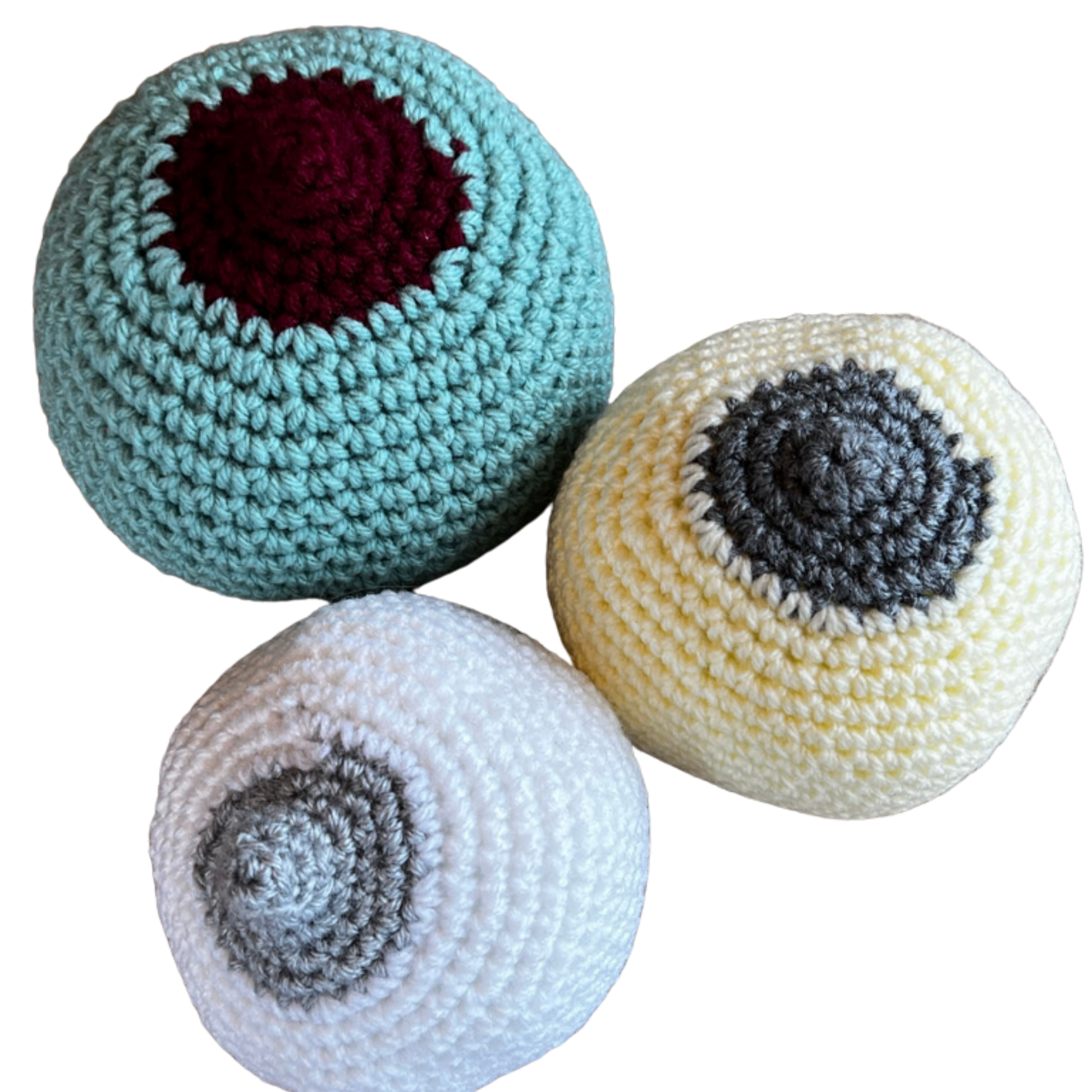 crocheted breast models to teach prenatal clients how to latch a baby at the breast. One large breast, mint green with a burgundy large nipple, one medium small cream coloured with a grey flattish nipple and one small white coloured breast with a grey perky nipple.