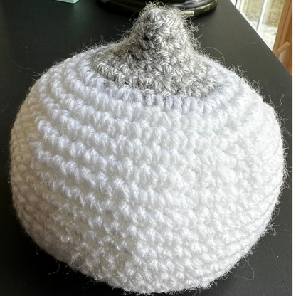 One medium-sized white crocheted breast model with a perky, grey nipple to teach latching and breastfeeding.